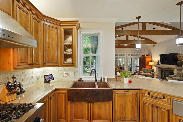 219 Abbott Ln, Saint Simons Island, GA 31522 - kitchen with wall chimney range hood, brown cabinetry, decorative backsplash, light stone counters, and plenty of natural light