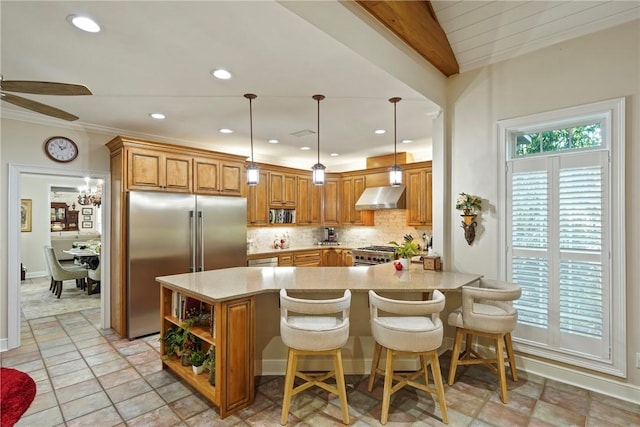 219 Abbott Ln, Saint Simons Island, GA 31522 - kitchen featuring wall chimney range hood, premium appliances, brown cabinetry, light countertops, and recessed lighting