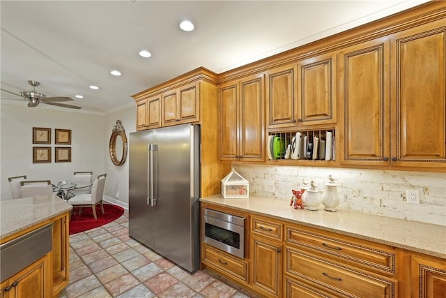 219 Abbott Ln, Saint Simons Island, GA 31522 - kitchen with appliances with stainless steel finishes, recessed lighting, backsplash, brown cabinetry, and stone finish flooring