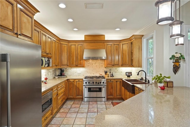 219 Abbott Ln, Saint Simons Island, GA 31522 - kitchen with high quality appliances, extractor fan, brown cabinetry, decorative backsplash, and recessed lighting
