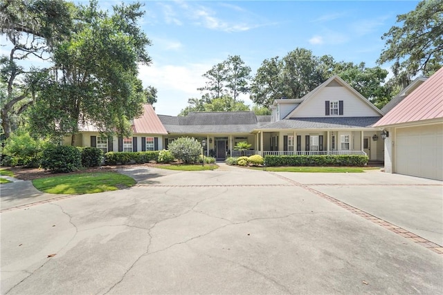 219 Abbott Ln, Saint Simons Island, GA 31522 - view of front facade with driveway, covered porch, and a garage