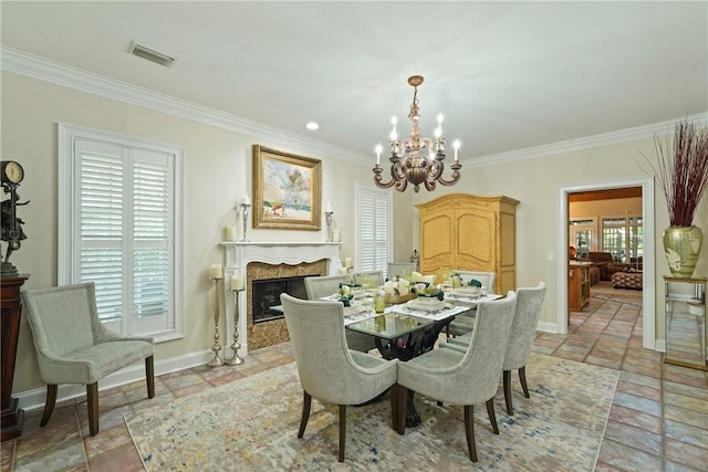 219 Abbott Ln, Saint Simons Island, GA 31522 - dining room featuring stone tile floors, a chandelier, ornamental molding, and a premium fireplace