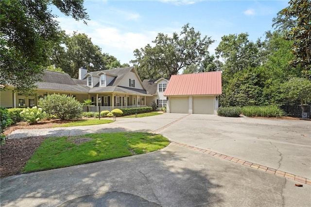 219 Abbott Ln, Saint Simons Island, GA 31522 - view of front facade featuring concrete driveway, a garage, and a chimney