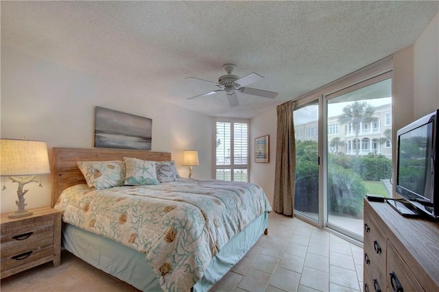 bedroom with access to outside, ceiling fan, light tile patterned flooring, and a textured ceiling