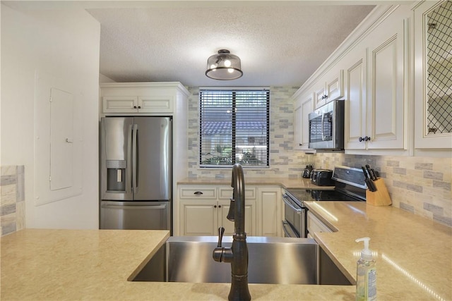 kitchen with white cabinets, sink, appliances with stainless steel finishes, and tasteful backsplash