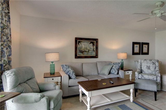 living room featuring ceiling fan, light tile patterned floors, and a textured ceiling