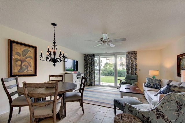 dining space featuring ceiling fan with notable chandelier and a textured ceiling