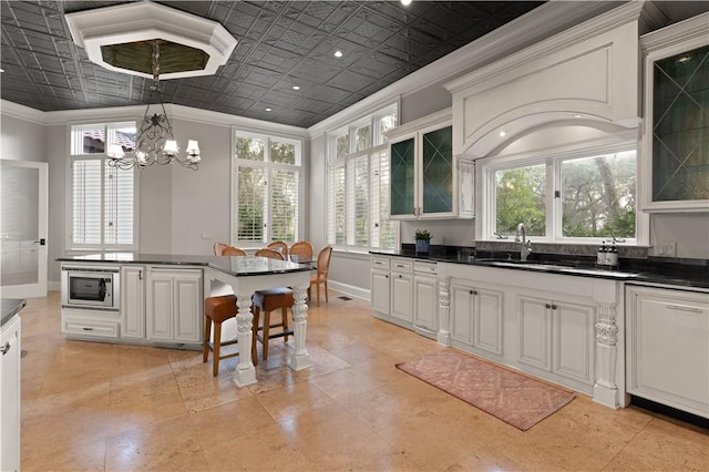 kitchen featuring white cabinetry, a wealth of natural light, and stainless steel microwave