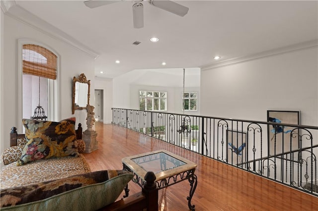 interior space with hardwood / wood-style floors, ceiling fan, and crown molding