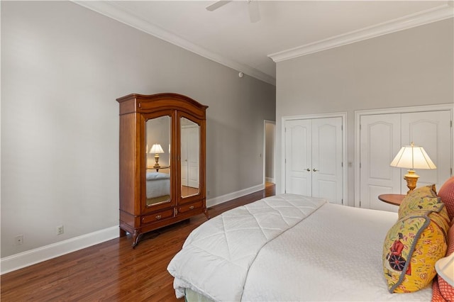 bedroom with two closets, crown molding, ceiling fan, and dark wood-type flooring