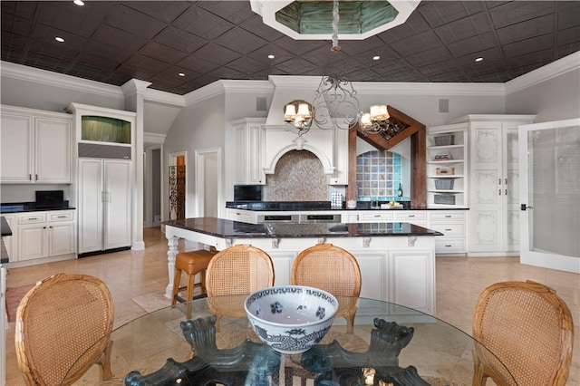 tiled dining area featuring crown molding and a notable chandelier