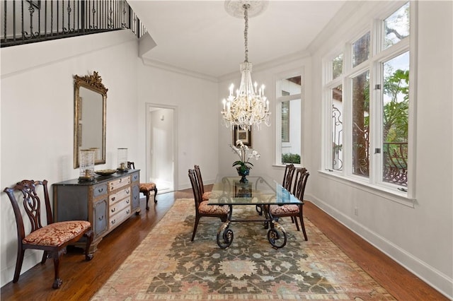 dining room featuring dark hardwood / wood-style flooring, an inviting chandelier, and ornamental molding