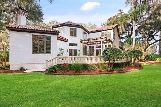 back of house with a pergola, a wooden deck, and a yard