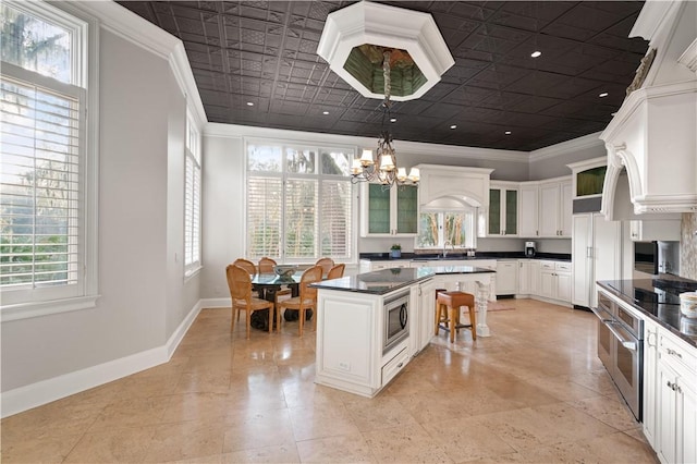 kitchen with white cabinets, plenty of natural light, pendant lighting, and stainless steel appliances