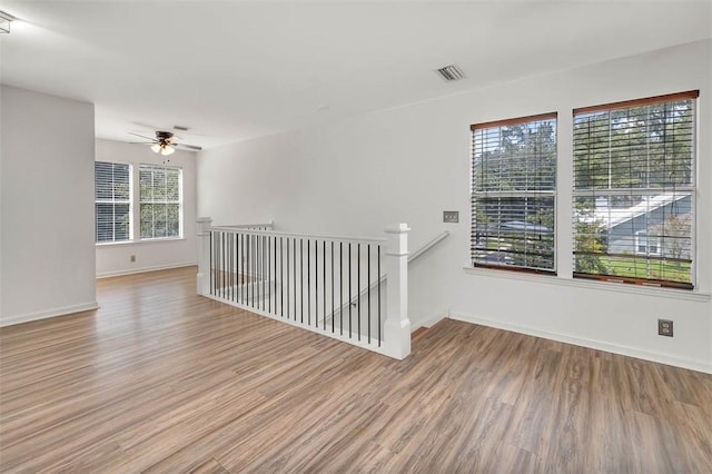 spare room with light hardwood / wood-style flooring, plenty of natural light, and ceiling fan