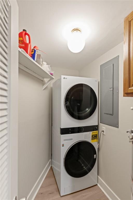 669 N Golf Villas, Saint Simons Island, GA 31522 - washroom featuring estacked washer and dryer, electric panel, and light wood finished floors