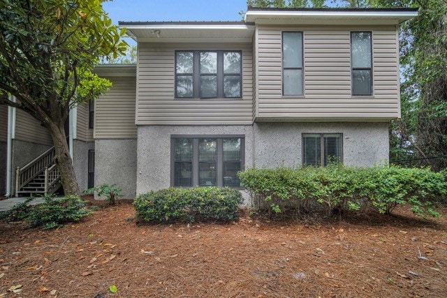 back of house with stucco siding and fence