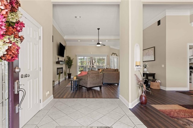 106 Hickory Pne, Brunswick, GA 31523 - entryway with crown molding, light tile patterned floors, ceiling fan, a glass covered fireplace, and baseboards