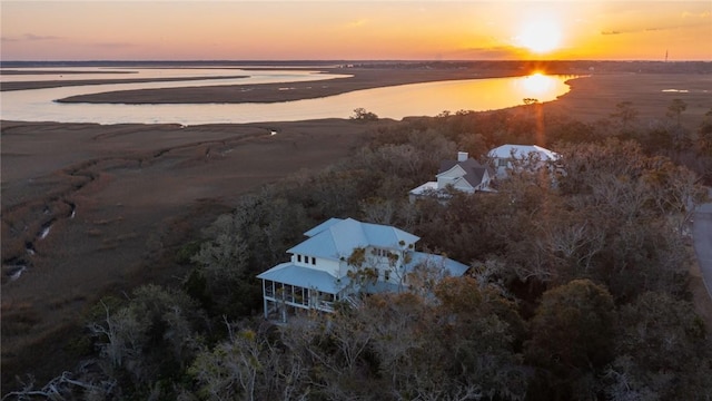 aerial view at dusk featuring a water view