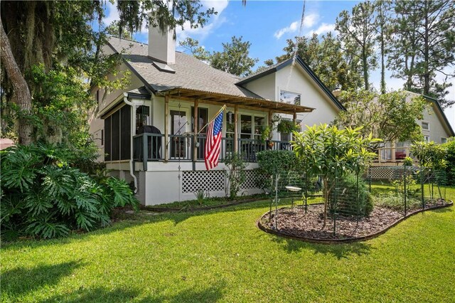 403 Indigo, Saint Simons Island, GA 31522 - rear view of house with stucco siding, a lawn, and a chimney