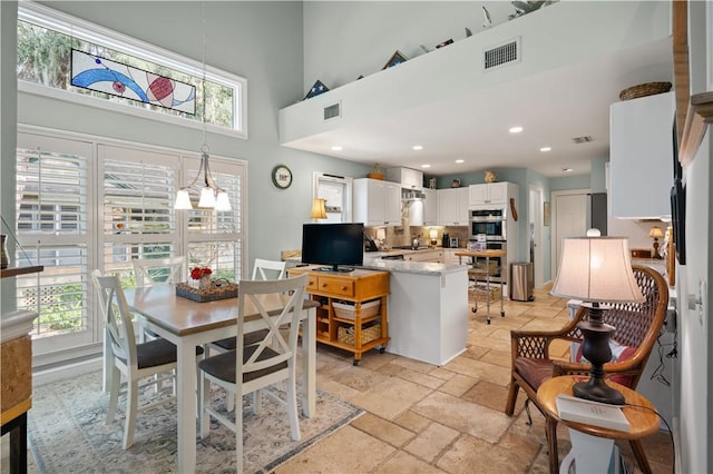 403 Indigo, Saint Simons Island, GA 31522 - dining space featuring recessed lighting, visible vents, stone tile flooring, and a towering ceiling