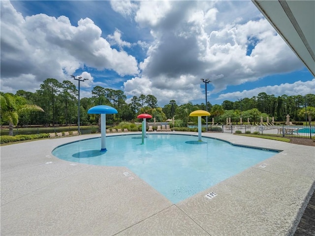 206 Placid Rd, Saint Marys, GA 31558 - community pool with a water play area, view of scattered trees, and a patio