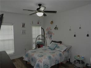 105 Lonnie Johnson Rd, Hazlehurst, GA 31539 - bedroom with multiple windows, a ceiling fan, and wood finished floors