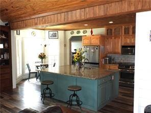 105 Lonnie Johnson Rd, Hazlehurst, GA 31539 - kitchen with black microwave, stove, fridge, a breakfast bar, and a center island with sink