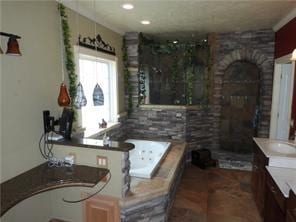 105 Lonnie Johnson Rd, Hazlehurst, GA 31539 - full bathroom featuring vanity, a stall shower, a garden tub, tile patterned floors, and a fireplace