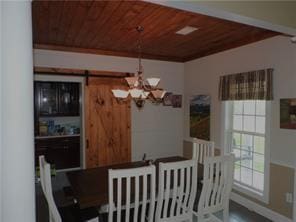 105 Lonnie Johnson Rd, Hazlehurst, GA 31539 - dining room with wood ceiling, a chandelier, and a barn door