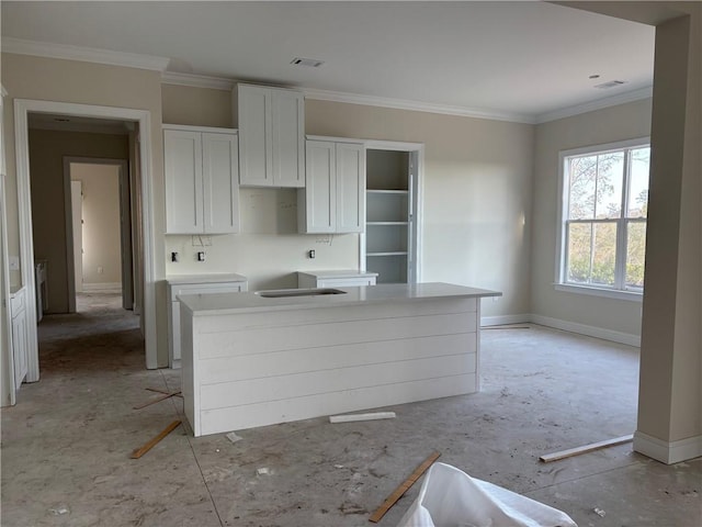 kitchen featuring white cabinetry, ornamental molding, a kitchen breakfast bar, and a kitchen island