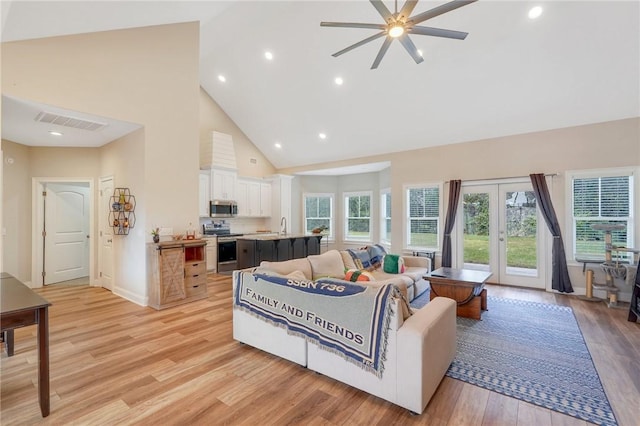 living room featuring french doors, ceiling fan, sink, high vaulted ceiling, and light hardwood / wood-style floors