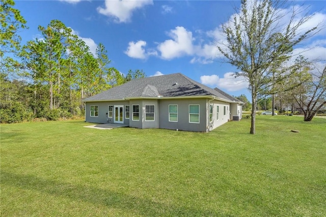 back of property featuring a lawn and french doors