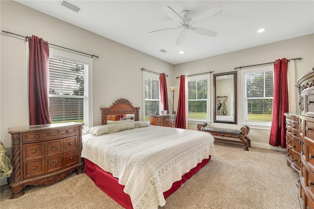 carpeted bedroom with multiple windows and ceiling fan