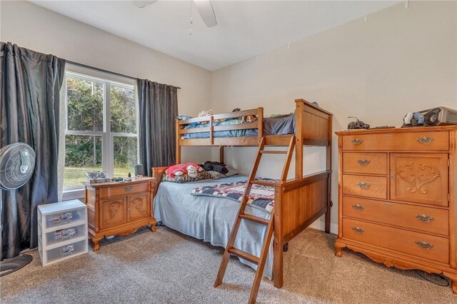 carpeted bedroom with multiple windows and ceiling fan