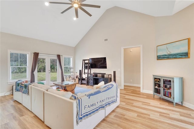 living room with ceiling fan, high vaulted ceiling, and light wood-type flooring