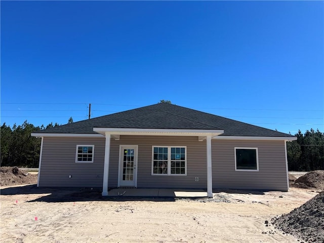 back of property featuring a shingled roof