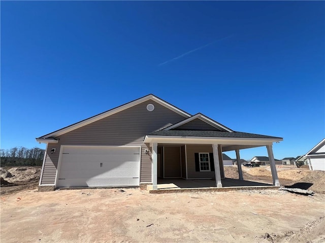 view of front of home featuring an attached garage, driveway, and a porch