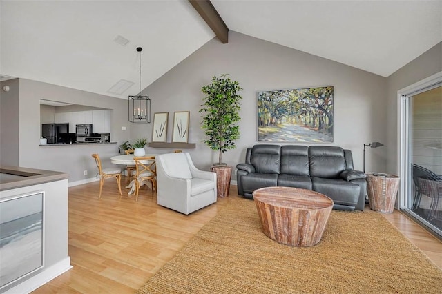 living room with wood-type flooring, vaulted ceiling with beams, and a notable chandelier