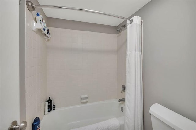 bathroom with toilet and shower / bath combo with shower curtain