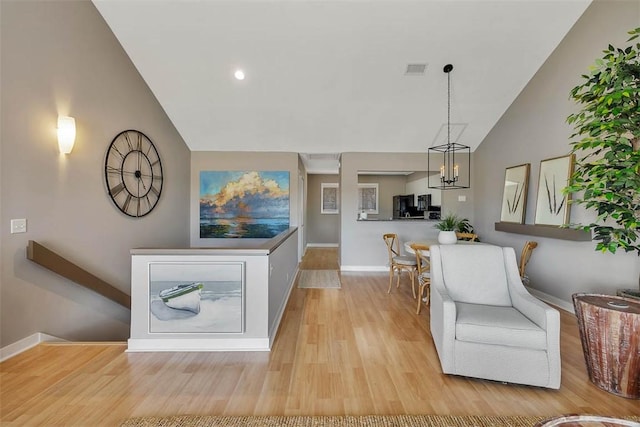 interior space with high vaulted ceiling, a chandelier, and light wood-type flooring