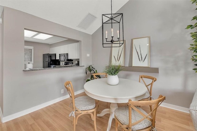 dining area with lofted ceiling and light hardwood / wood-style flooring