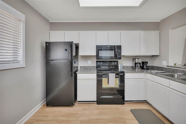 kitchen featuring white cabinetry, light hardwood / wood-style floors, and black appliances