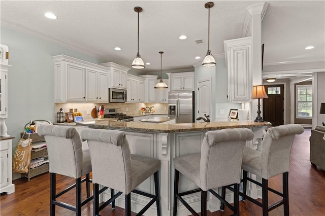 kitchen featuring white cabinets, kitchen peninsula, dark wood-type flooring, and appliances with stainless steel finishes