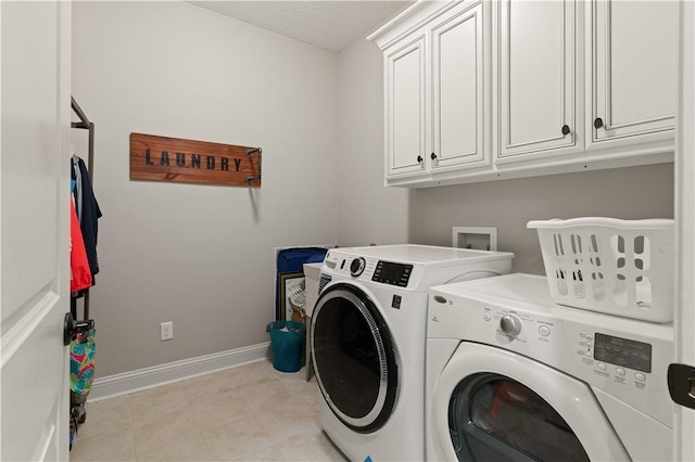 washroom with washer and dryer and cabinets