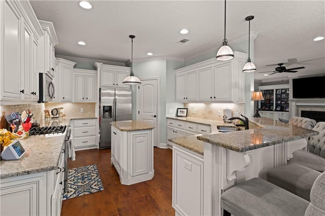 kitchen with a center island, white cabinets, sink, ceiling fan, and stainless steel appliances