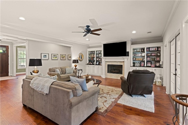 living room with hardwood / wood-style floors, ceiling fan, ornamental molding, and a tile fireplace