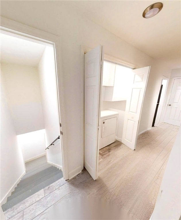 interior space featuring washer / dryer, light wood-type flooring, and baseboards