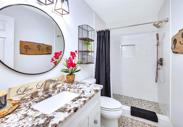 bathroom featuring a tile shower, toilet, and vanity