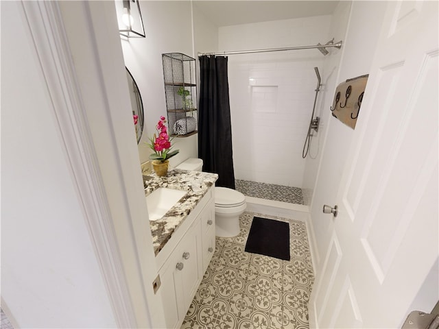 bathroom featuring vanity, walk in shower, tile patterned floors, and toilet